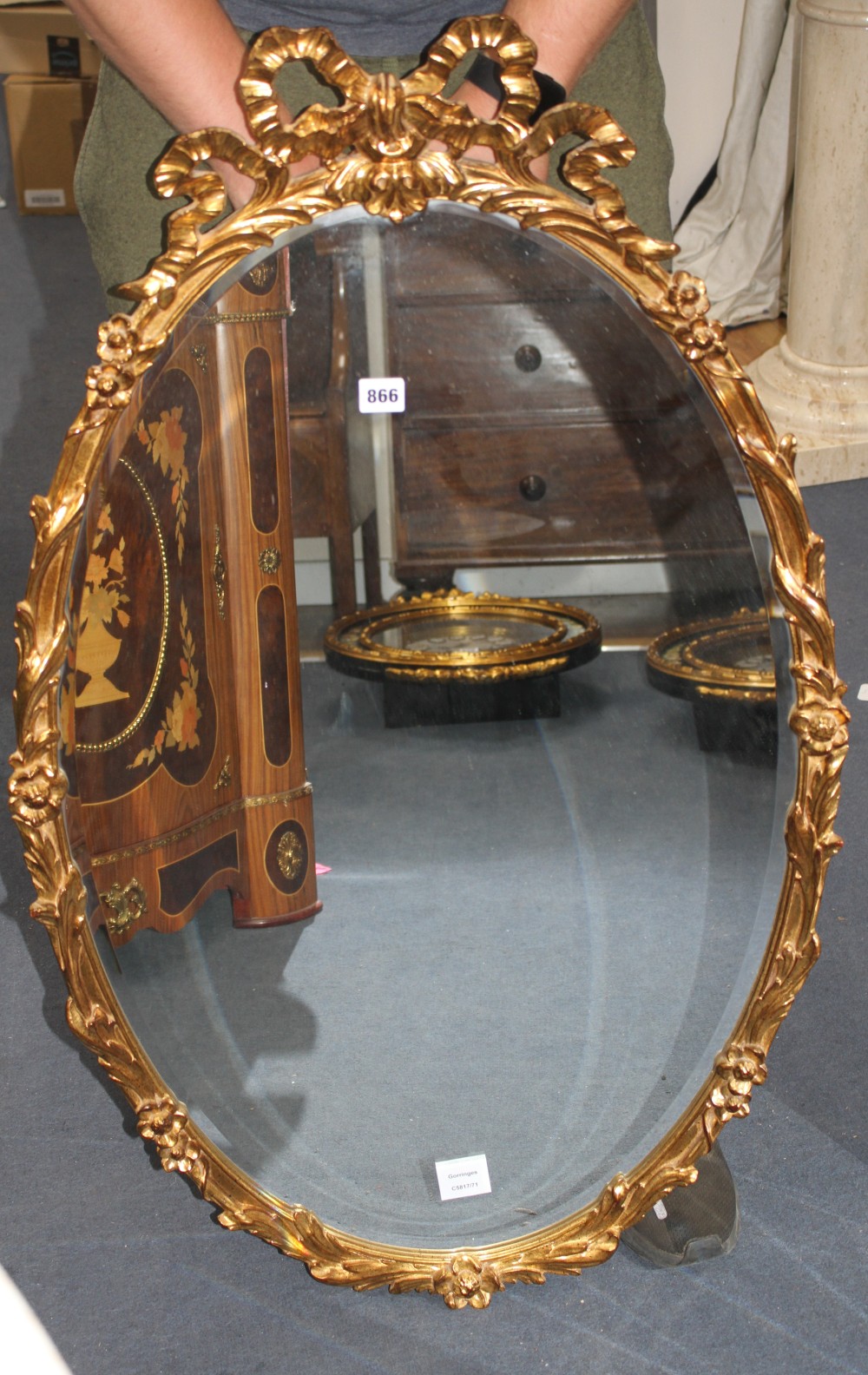 An oval gilt composition wall mirror with ribbon tied decoration, W.64cm H.100cm